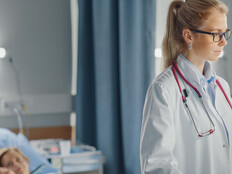 doctor looks at data on computer at the bedside