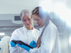researchers discuss data on tablet in lab