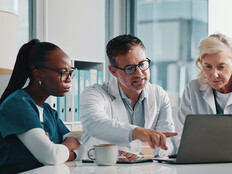 clinicians look at data on laptop