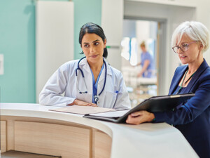 clinicians and administrators collaborate at hospital desk