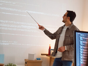 man teaches coding class using projector