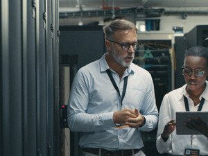 IT professionals look at tablet in data center room