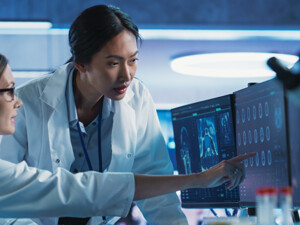 medical researchers looks at images on a monitor in a lab