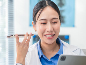 Doctor using phone to dictate to tablet