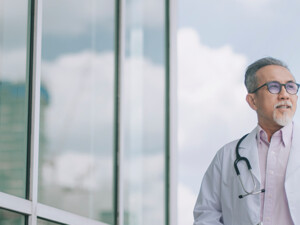 doctor in front of clouds and reflective building