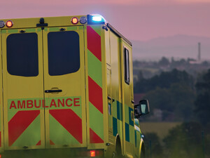 ambulance driving down country road at sunset