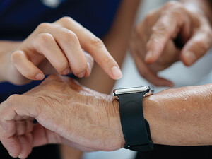 nurse helps man with wearable device
