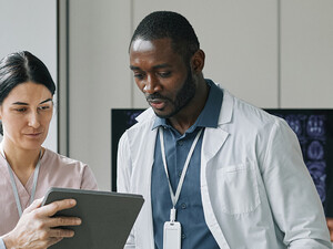 team looks at data on tablet and monitor