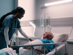 nurse talks to patient in hospital bed