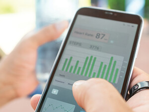 person with wearable ring checks app on phone