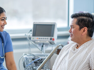 nurse talks with patient in hospital room