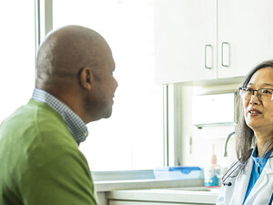 doctor talks with patient in exam room