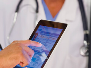 nurse and doctor look at EHR on tablet and monitor