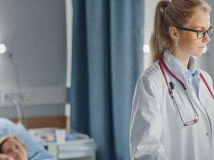 doctor looks at data on computer at the bedside