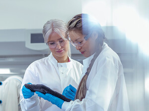researchers discuss data on tablet in lab