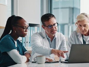clinicians look at data on laptop