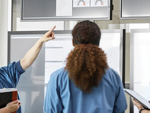 Medical professionals discussing over screens 