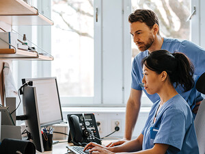 clinicians looking at computer monitor in office