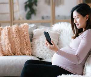 pregnant women looks at app on phone
