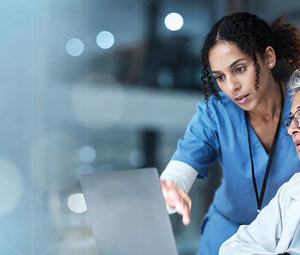 nurse and physician collaborate over laptop