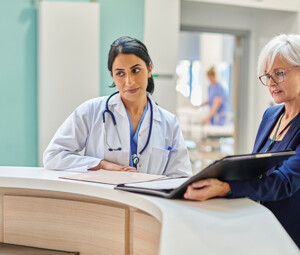 clinicians and administrators collaborate at hospital desk