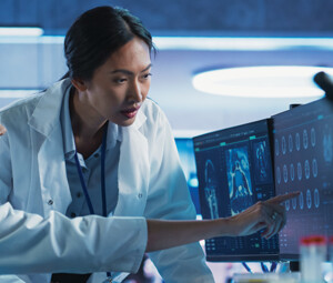 medical researchers looks at images on a monitor in a lab