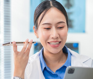 Doctor using phone to dictate to tablet
