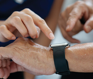 nurse helps man with wearable device